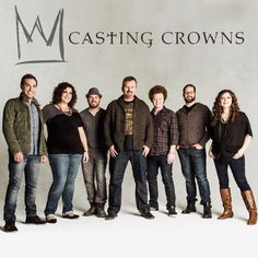 a group of people standing next to each other in front of a casting crowns sign