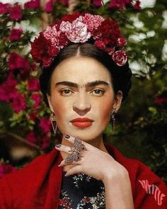 a woman with flowers in her hair wearing a red kimono and holding a ring