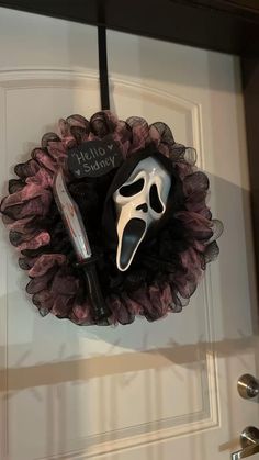 a mask and knife hanging on a door