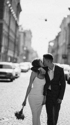 a man and woman kissing on the street