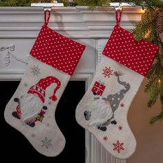 two christmas stockings hanging from a mantel