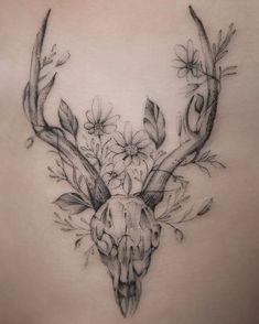 the back of a woman's stomach with a deer skull and flowers on it