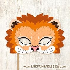 a paper lion mask with eyes closed on a wooden background that says free printable