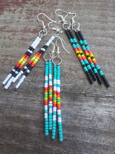 three different colored beads hanging from earrings