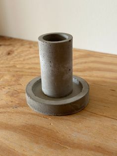 a concrete cup sitting on top of a wooden table