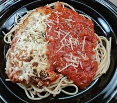 a black plate topped with spaghetti and sauce