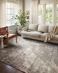 a living room filled with furniture and windows