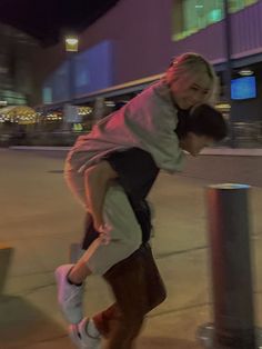 a young man riding a skateboard on top of a metal pole next to a sidewalk