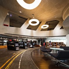 the interior of a library with chairs and bookshelves on either side of the room