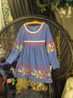 "70s border print blue dress with embroidered florals and zig zag trim. It's a mini dress with an empire  waist seam and long puffy sleeves gathered to 5 1/2\" long fitted cuffs. Made of a textured cotton blend, it has colors of red, green, orange, blue and white leaves & flowers with red and white zig zag rik-rak trim. It's a floral border print that makes good use of the patterns. The blue metal zipper tab says Robin! The neckline is a scoop style, and the bodice is fitted with darts, a gently gathered skirt, and long sleeves. It zips on the back. No tags. It fits like a modern USA size 2 -4 - (about), A size Xtra Small , No stretch. bust - 34\"   empire waist seam- 25\"     bodice length - 11 1/2\"                     hips - 48\"  back shoulders - 14\" sleeves - 22\" wrist - 7\" Length Blue Fitted Bohemian Vintage Dress, Fitted Blue Bohemian Vintage Dress, Vintage Floral Embroidered Dress For Fall, Vintage Embroidered Fall Dresses, Retro Blue Puff Sleeve Dress, Spring Blue Cotton Vintage Dress, Spring Blue Vintage Cotton Dress, Vintage Blue Embroidered Dresses, Vintage Smock Dress For Spring