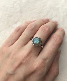 "A Boho Iridescent Round Smooth Genuine Natural Labradorite Sterling Silver Ring featuring a comfort fit band with a bezel around the stone. PLEASE NOTE Labradorite will vary in color as each gemstone is unique. This is a mesmerizing gemstone known for it's flash. Wrapped in a box ready for gift giving.(r-497) RING INFO ---------------- STERLING SILVER Stone 10MM (0.39inches) High Quality Sterling Silver 925 Tarnish Resistant *Model is wearing a size 5 *Follow us @belesasjewelry on Instagram for Adjustable Round Midi Rings With Bezel Setting, Adjustable Midi Rings With Bezel Setting, Adjustable Stackable Round Moonstone Ring, Adjustable Round Opal Ring, Spiritual Style, Adjustable Round Opal Ring Spiritual, Adjustable Round Opal Ring For Spiritual Purposes, Adjustable Silver Moonstone Ring For Everyday Wear, Adjustable Moonstone Ring For Everyday, Adjustable Everyday Moonstone Ring