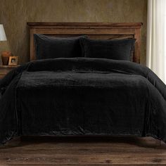 a bed with black comforter and pillows in a room