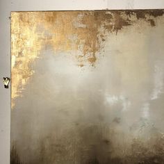 an abstract painting with gold and silver paint