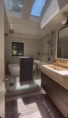 a bathroom with a skylight, sink and bathtub