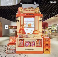 an orange and white stand with snacks on it in a mall or shopping center for children's toys