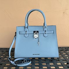 New With Tag Michael Kors Hamilton Medium Satchel Shoulder Crossbody Bag Pebbled Leather Pale Blue 100% Authentic Retail: $558.00 Plus Tax *Please See The Measurement For The Size* No Dust Bag Michael Kors Logo At Front Snap Top Closure Silver Toned Hardware Mk Key & Lock On Front 4 Protective Feet Custom Mk Fabric Lining 1 Slip-In Pockets 1 Zipper Pocket 13" (L) X 9"(H) X 5"(D) Strap: 4", 18"- 24" Very Clean, Smoke-Free And Pet-Free Environment. Blue Top Handle Satchel With Silver-tone Hardware, Luxury Blue Satchel With Silver-tone Hardware, Light Blue Top Handle Shoulder Bag With Gold-tone Hardware, Designer Light Blue Bag With Detachable Strap, Designer Light Blue Bags With Detachable Strap, Blue Top Handle Shoulder Bag With Silver-tone Hardware, Blue Shoulder Bag With Silver-tone Hardware And Top Handle, Blue Office Bag With Turn-lock Closure, Blue Travel Bag With Turn-lock Closure