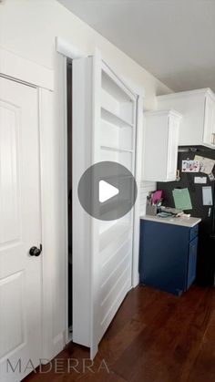 an open door leading to a kitchen with white cabinets and wood floors in the background