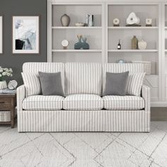 a living room scene with focus on the couch and bookshelves, which are decorated in neutral tones