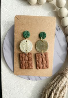 the earrings are made out of clay, and have green leaves on top of them