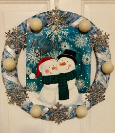 a christmas wreath with two snowmen on it