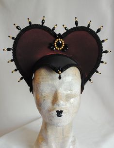 This vampire style gothic headdress is covered with taffeta and embellished with black breaded trimming all around the edges.It is further decorated with black beaded details that create a halo effect. The piece is completed with a black crystal handmade element placed at the center in order to create even more visual interest! Choose between burgundy (pictured), black or dark blue as well as having total black crystal beading or a combination of black crystals and golden pearls (pictured). The Medieval Masquerade Mask For Halloween, Black Medieval Masquerade Mask, Black Medieval Masquerade Mask For Fantasy Events, Medieval Black Masquerade Mask For Fantasy Events, Medieval Black Masquerade Mask, Black Steampunk Costume Accessories For Fantasy Events, Medieval Masquerade Mask For Halloween Cosplay, Gothic Costume Hats And Headpieces For Masquerade Carnival, Gothic Costume Hats For Masquerade And Carnival