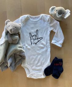 Sometimes the simplest message can be the most powerful! Our adorably decorated baby bodysuits are perfect for your baby's social life from lounging at home, visiting grandparents or cruising in the neighborhood or park.  The design on the bodysuit is handmade with care and attention to detail. We use Gerber® brand onesies which are incredibly soft and made from 100% cotton. We recommend ordering one size larger.  Your bodysuit arrives beautifully packaged and is the perfect baby shower or new-baby welcome gift. Photo props not included. Please message us with questions or for custom requests to introduce your baby's personality in a unique way. Thank you for choosing hello asobi. Personalized White Bodysuit For Gift, Unisex Casual Onesie - Perfect As A Gift, Father's Day Gift Cotton Onesie, Unisex Casual Onesie As A Gift, Unisex Casual Onesie As Gift, White Letter Print Bodysuit As Gift, Casual Letter Print Onesie As Gift, Mother's Day Cotton Onesie Gift, White Cotton Bodysuit Gift