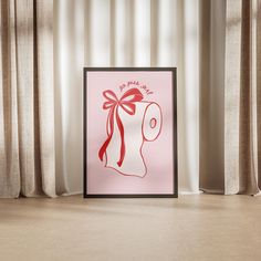 a pink poster with a red bow on it in front of a curtained window