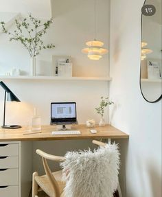 a laptop computer sitting on top of a wooden desk next to a white chair and lamp