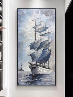 a painting on the wall of a room with a large sailboat in the water