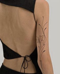 the back of a woman's bra with flowers on her left arm and shoulder