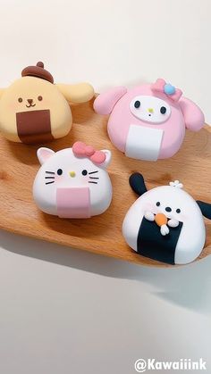 there are many different shaped items on the wooden tray, including cats and pandas