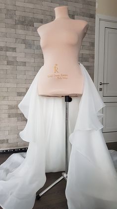 a mannequin with a wedding dress on display in front of a brick wall