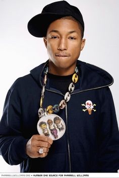 a man in a black jacket and hat is holding a necklace with charms on it