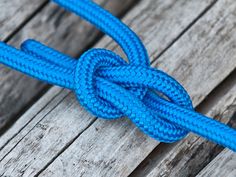 a blue rope is tied to a wooden plank