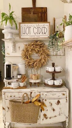 an old dresser is decorated with wreaths and coffee cups