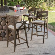 an outdoor table with chairs around it and a grill on the outside wall behind it