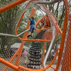 a young boy is climbing on an obstacle course