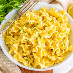 a white bowl filled with pasta and parsley