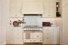 a kitchen with white cabinets and marble counter tops is pictured in this image from the front view