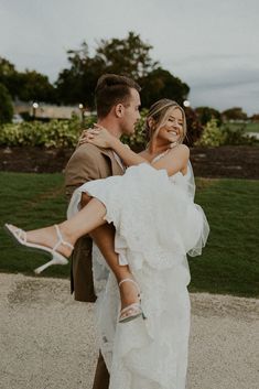 a man carrying a woman on his back while she is holding her in the air