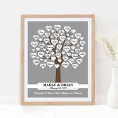 personalized family tree with hearts in grey and white, framed on wall next to vase