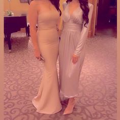 two women standing next to each other in formal wear and one is wearing a dress