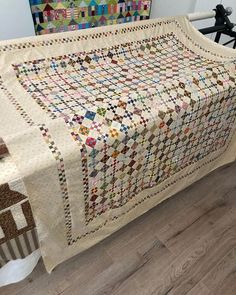 a quilted bed cover with houses on it and a bicycle parked in the background