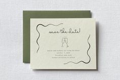 save the date card with two champagne glasses on it, and an olive green envelope