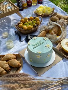 a blue cake sitting on top of a table next to bread and other food items