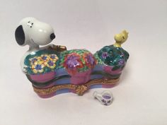 a dog figurine sitting on top of a bed next to a toy duck