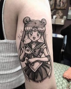 a girl with a bear tattoo on her arm is holding a teddy bear in her arms