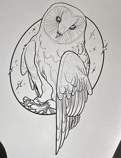 an owl sitting on top of a piece of paper next to a pen and ink drawing