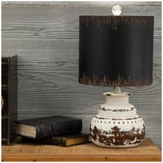 a table lamp sitting on top of a wooden shelf next to an old bookcase