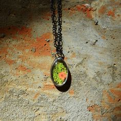 Bayou Glass Arts Green Moss Pendant with Orange Flower 1 1/2"H x 1"W Real dried moss with single flower, your choice of Orange, Pink or Yellow Choice of 24", 28" or 36" fully adjustable figaro chain Choose Shiny Black/Gunmetal or Shiny Silver finish Truly Hand Made in USA FREE 1st Class Domestic Shipping, Expedited Shipping Available Gift Wrapping and Messaging Offered Style #2866O Cottagecore Jewelry Forest floor jewelry. Cottagecore feel with moss and a single flower encased in quality glass. Moss Necklace, Cottagecore Jewelry, Terrarium Jewelry, Forest Floor, Best Gifts For Her, Figaro Chains, Figaro Chain, Flower Pendant Necklace, Orange Flower